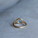 Back view of solid 14k yellow gold signet ring with bezel set bright blue sheen moonstone. Gold ring has brushed, matte finish
