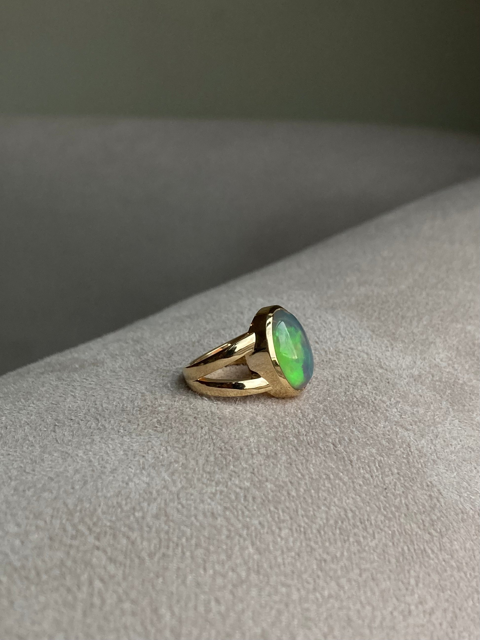 Black and green opal bezel set in solid 14k yellow gold statement ring with split shank. 